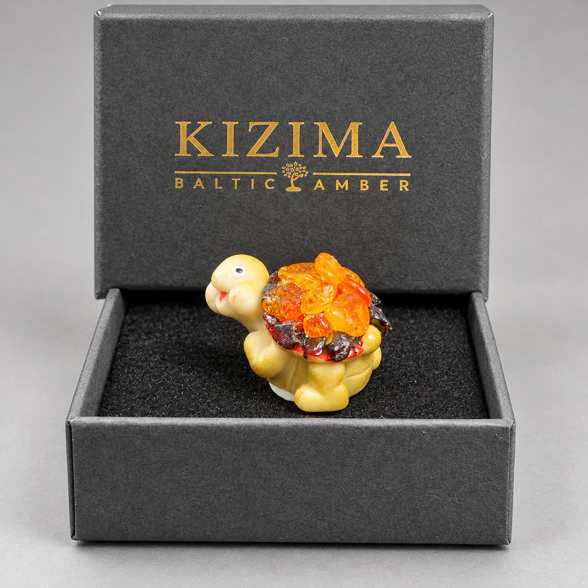 Baltic amber mini turtle figurine in an open KIZIMA® gift box — ready-to-give stocking stuffer