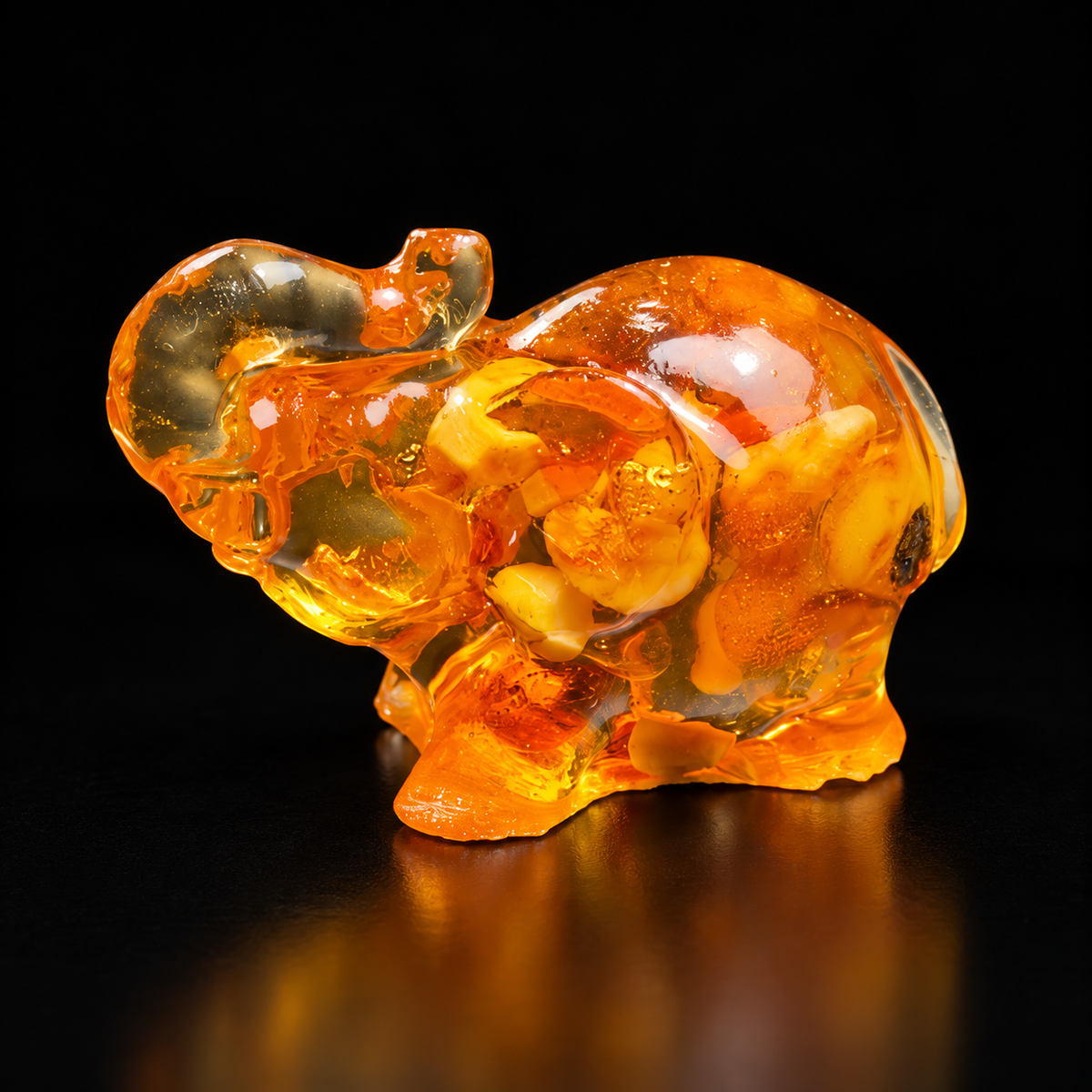 Made in USA Natural Baltic Amber mini elephant figurine, 3 cm, trunk raised, honey-cognac amber, black studio background — KIZIMA®