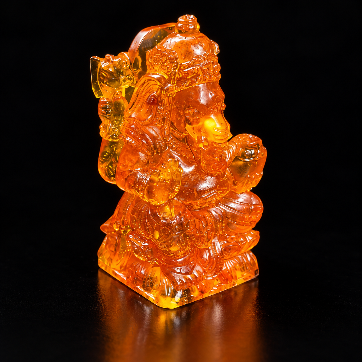 Made in USA Natural Baltic Amber small Ganesha statue, 7 cm seated elephant god, honey-orange amber, black studio background — KIZIMA®