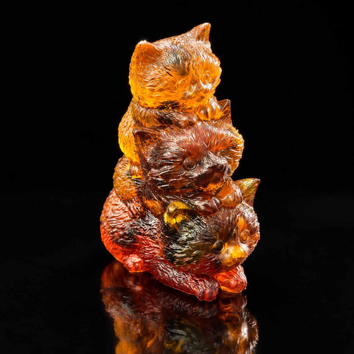 Made in USA Natural Baltic Amber three-kitten family figurine by KIZIMA®, 8 cm stacked cats in honey, cognac and dark red amber, black studio background