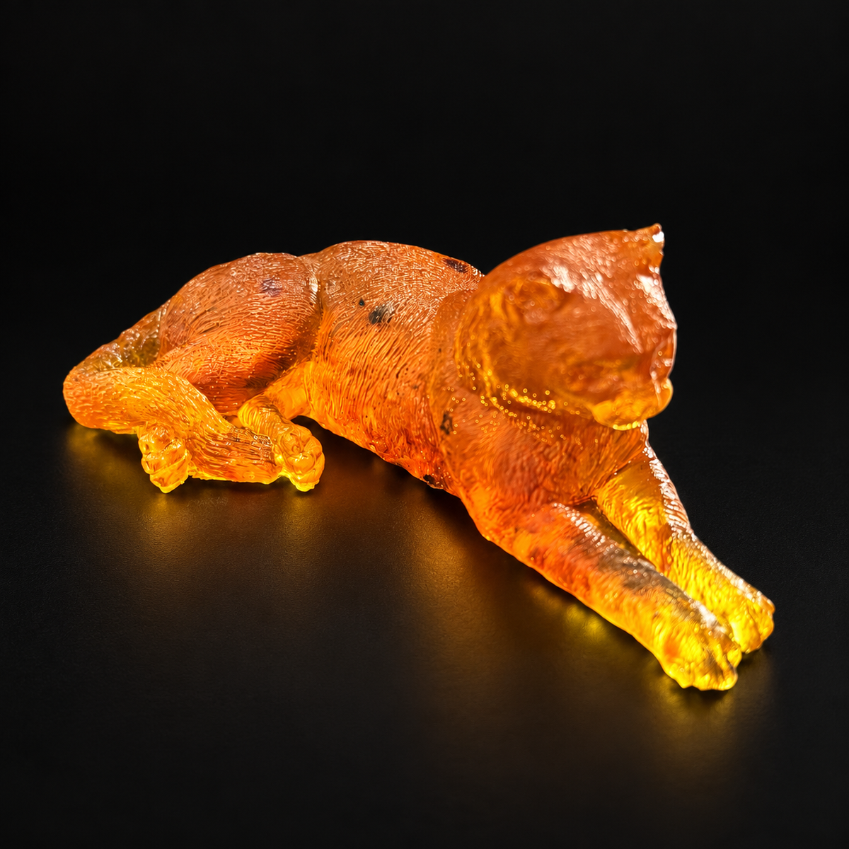 Made in USA Natural Baltic Amber reclining cat figurine by KIZIMA®, 11 cm orange-gold lying cat with extended paws, black studio background