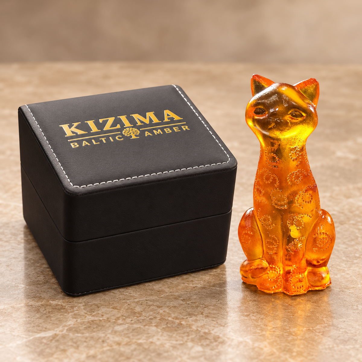 Made in USA Natural Baltic Amber paisley cat figurine by KIZIMA® beside the black KIZIMA® gift box with gold lettering