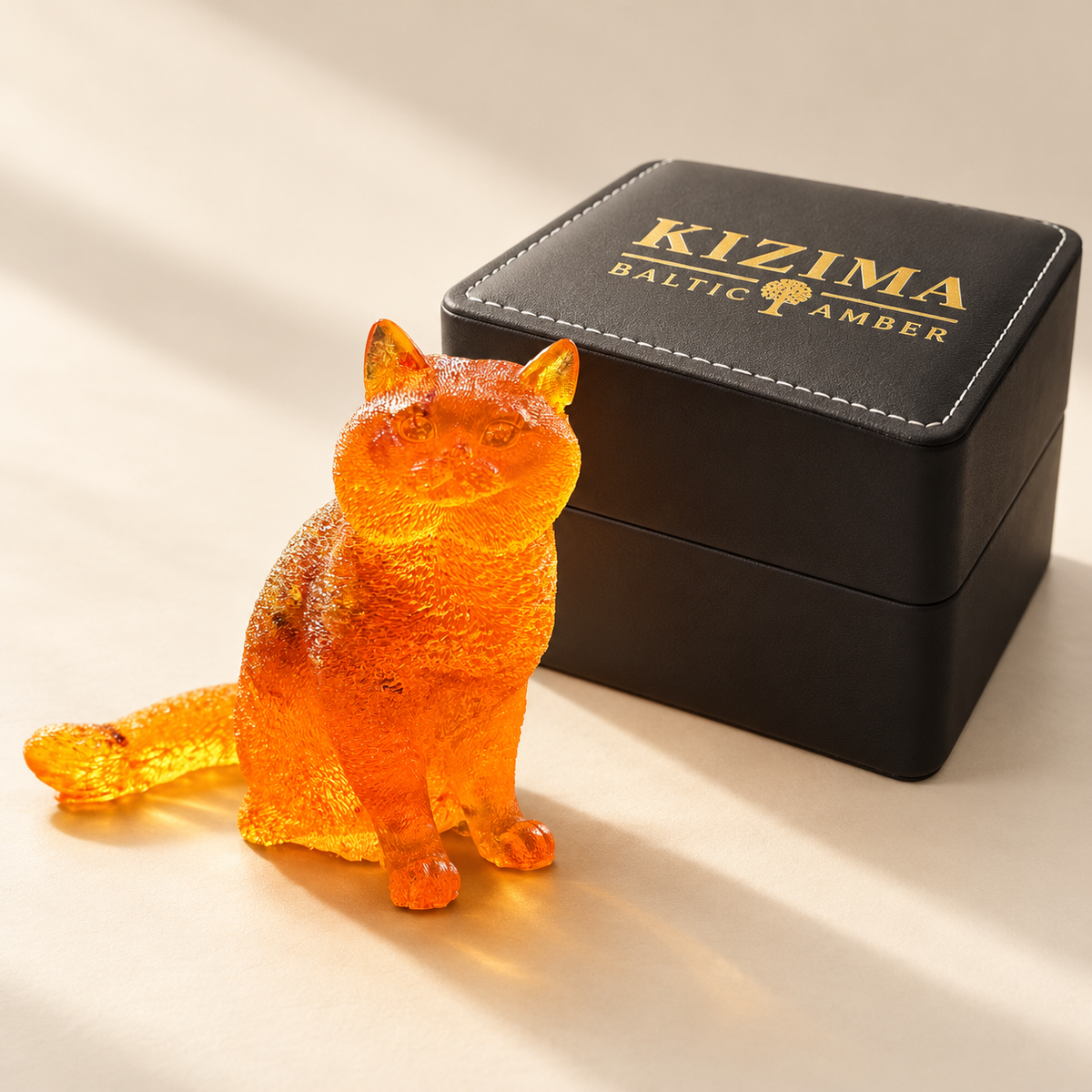 Made in USA Natural Baltic Amber fluffy cat figurine by KIZIMA® beside the black stitched KIZIMA® gift box