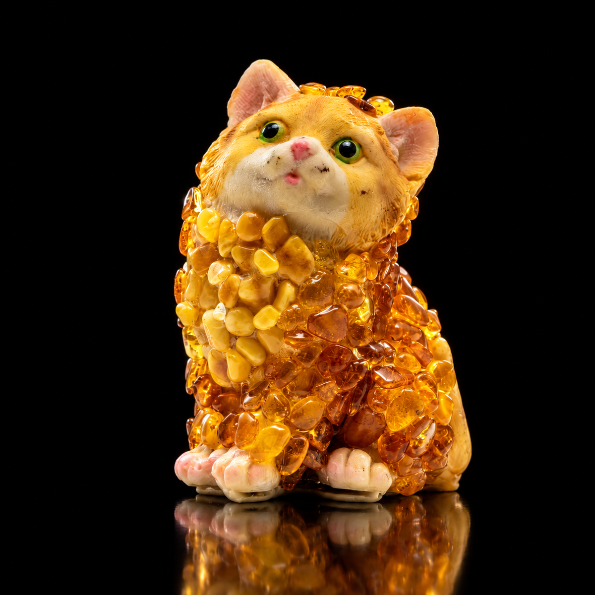 Natural Baltic Amber sitting cat figurine by KIZIMA®, honey and cognac mosaic, black background, side view