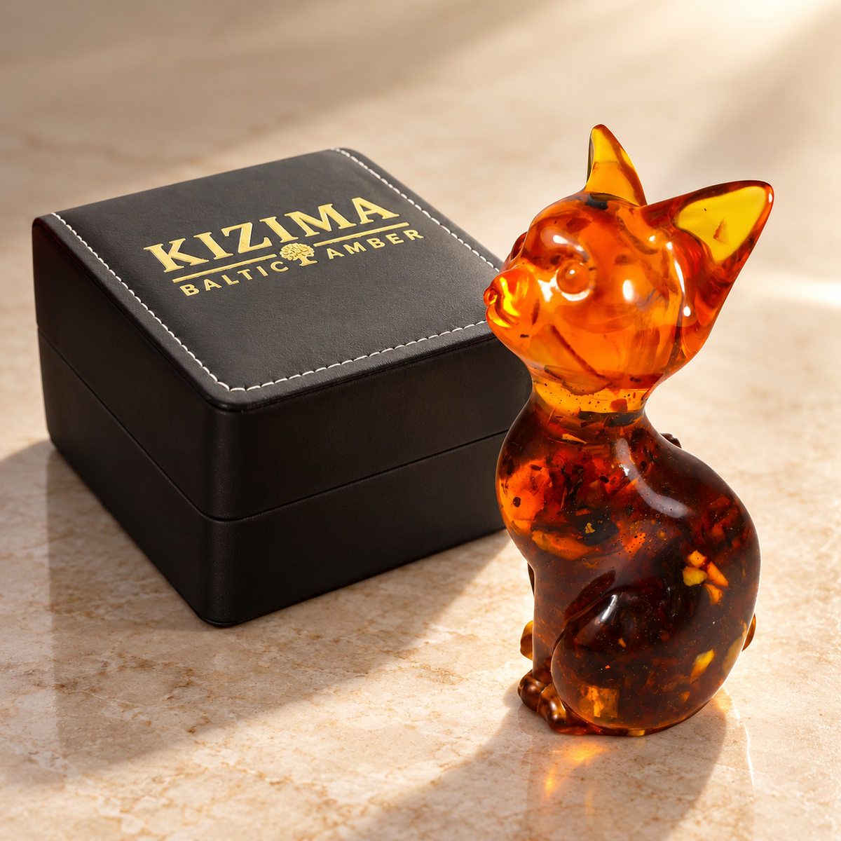 KIZIMA amber cat figurine beside the actual black stitched branded gift box