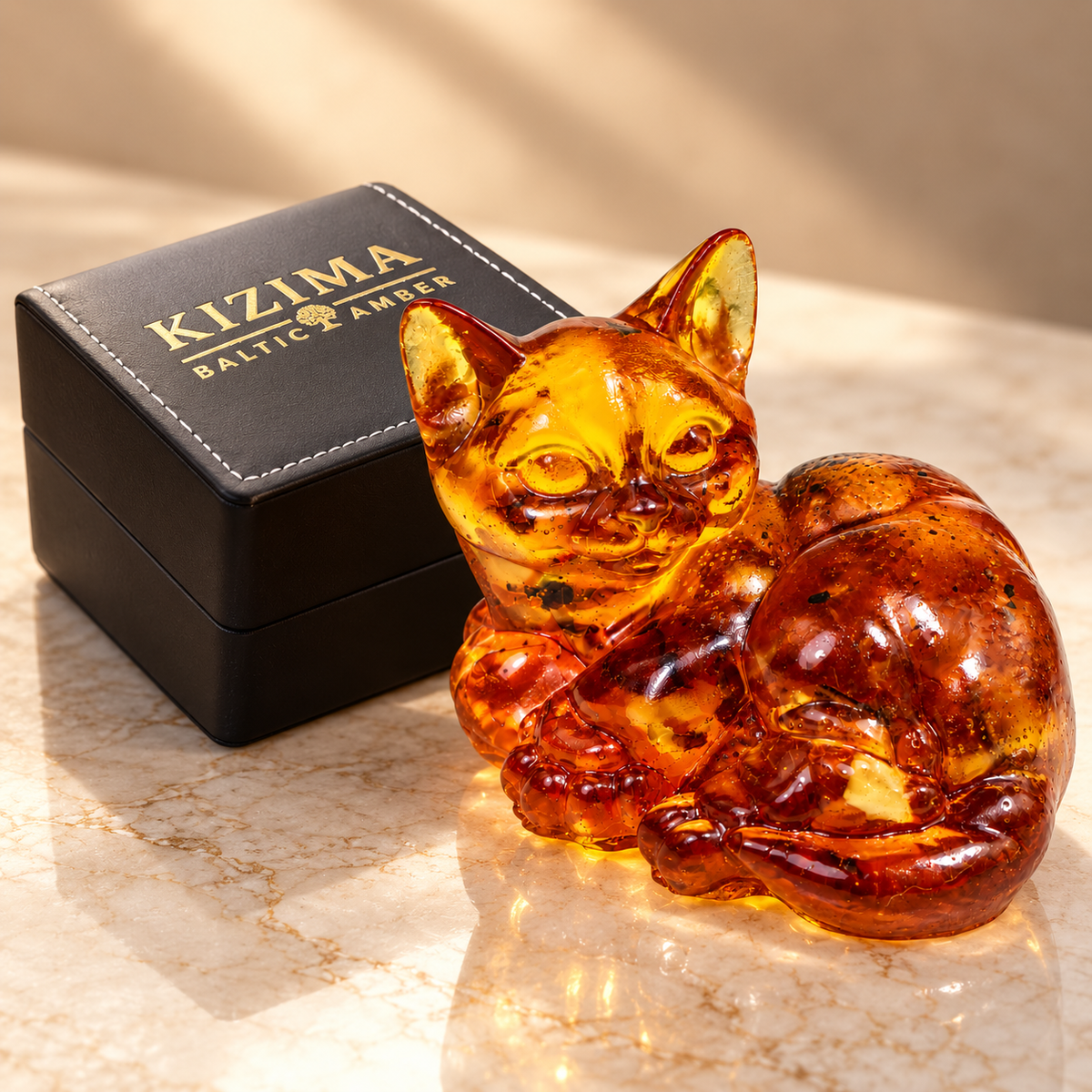 KIZIMA amber lying cat beside the actual black stitched branded gift box