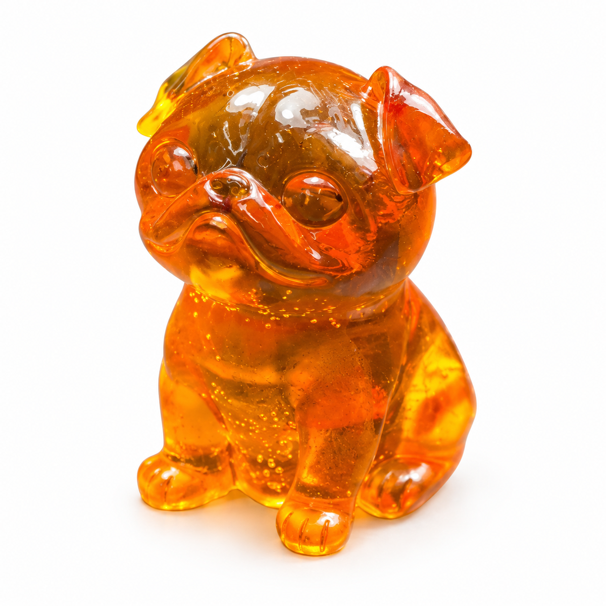 Seated amber pug on white, showing folded ears, rounded cheeks and front paws beneath a smooth golden-orange body.