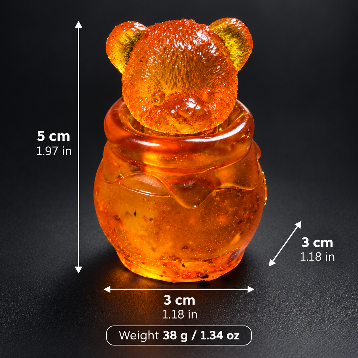 Amber bear head honey jar with measurement arrows showing 5 cm height, 3 cm width, 3 cm depth and 38 g weight, with imperial conversions.