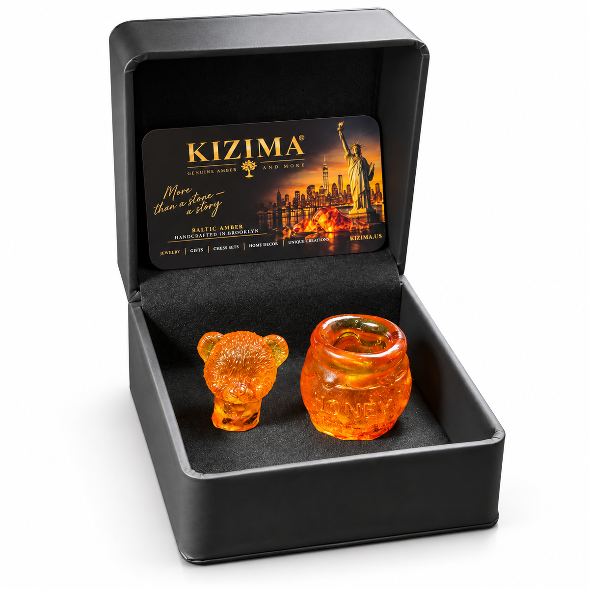 Amber bear head lid and open honey pot container in a black KIZIMA gift box with a branded card, photographed on white.
