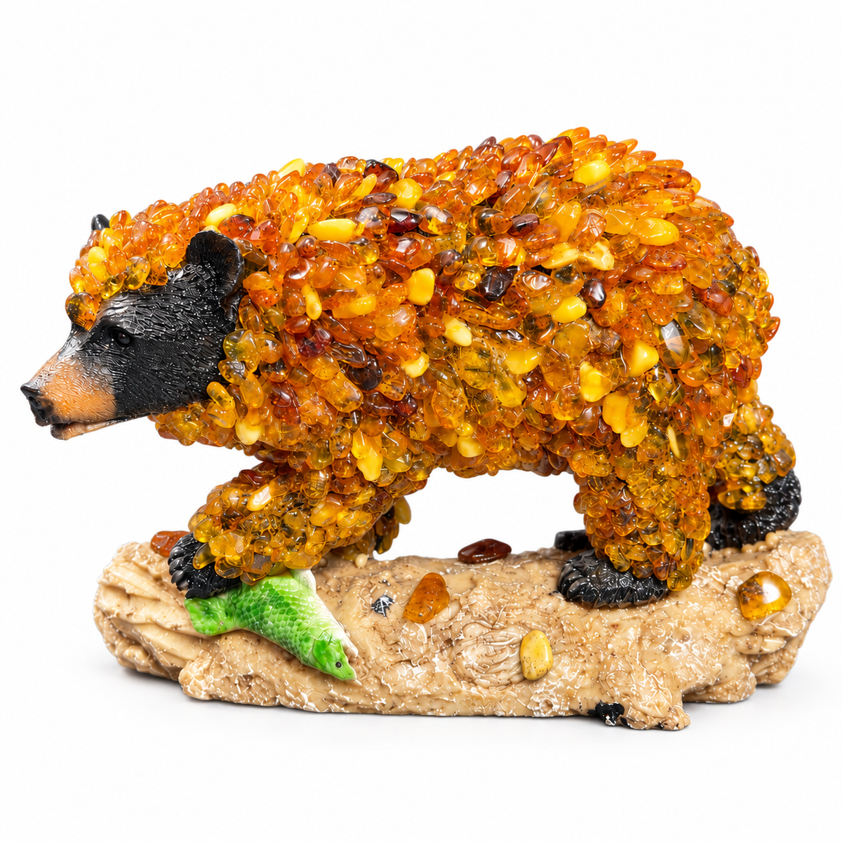 Baltic amber bear with black head and green fish on beige log isolated on pure white background