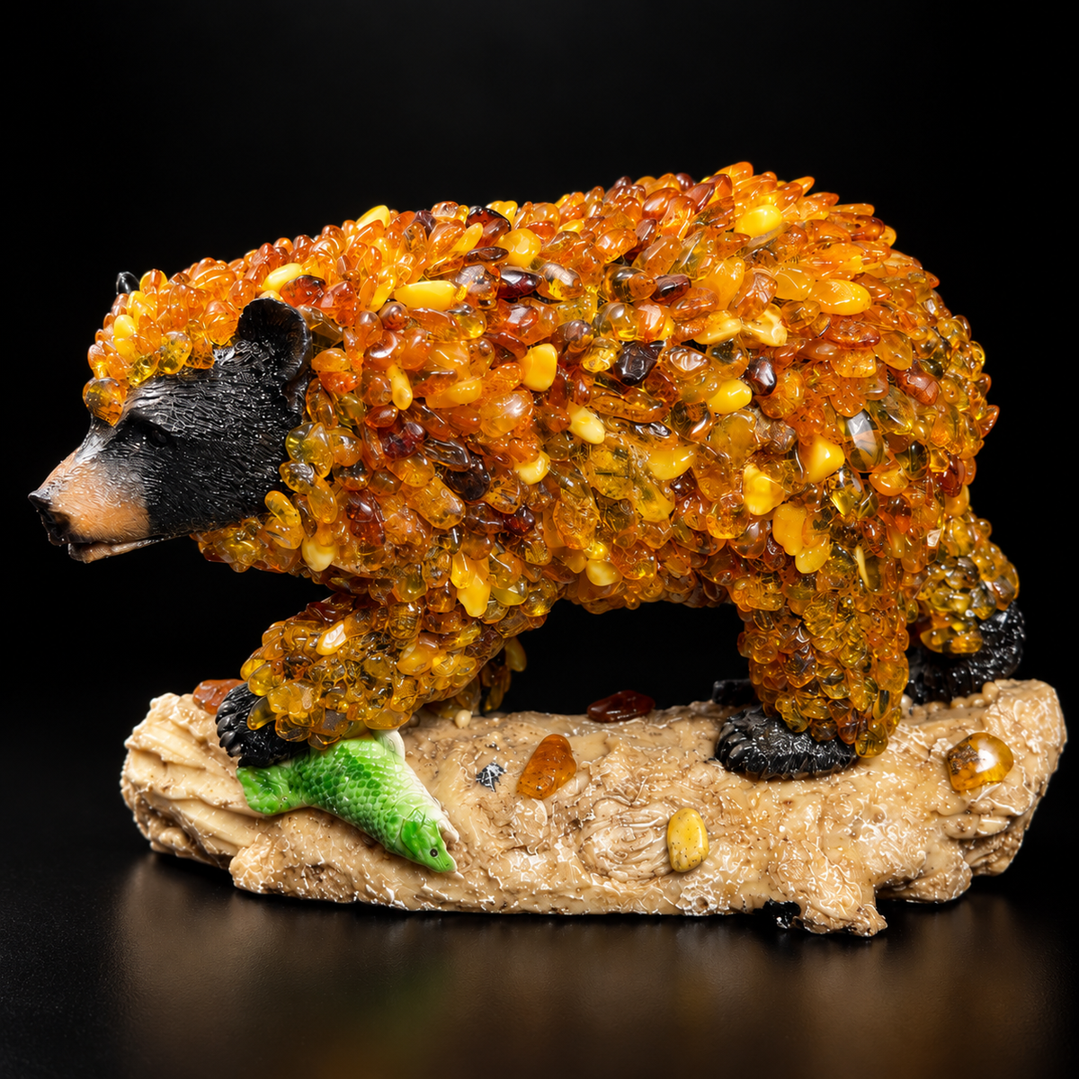 Baltic amber black bear with green fish on a beige log, premium black studio photograph
