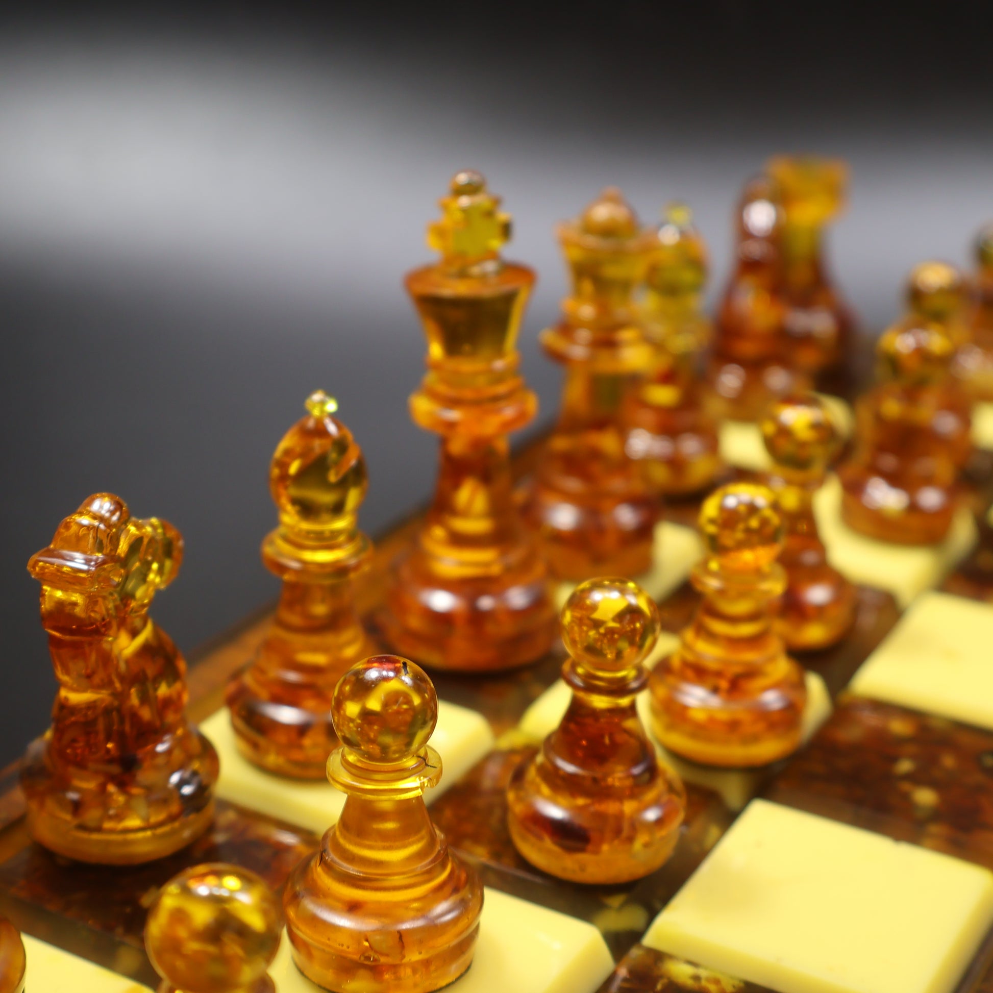 Amber chess set on rattan wood inlaid board side view, genuine Baltic amber chess pieces handcrafted KIZIMA USA