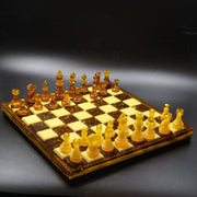 Full view of Baltic amber chess set with 32 pieces on natural rattan wood inlaid chess board, made in USA by KIZIMA