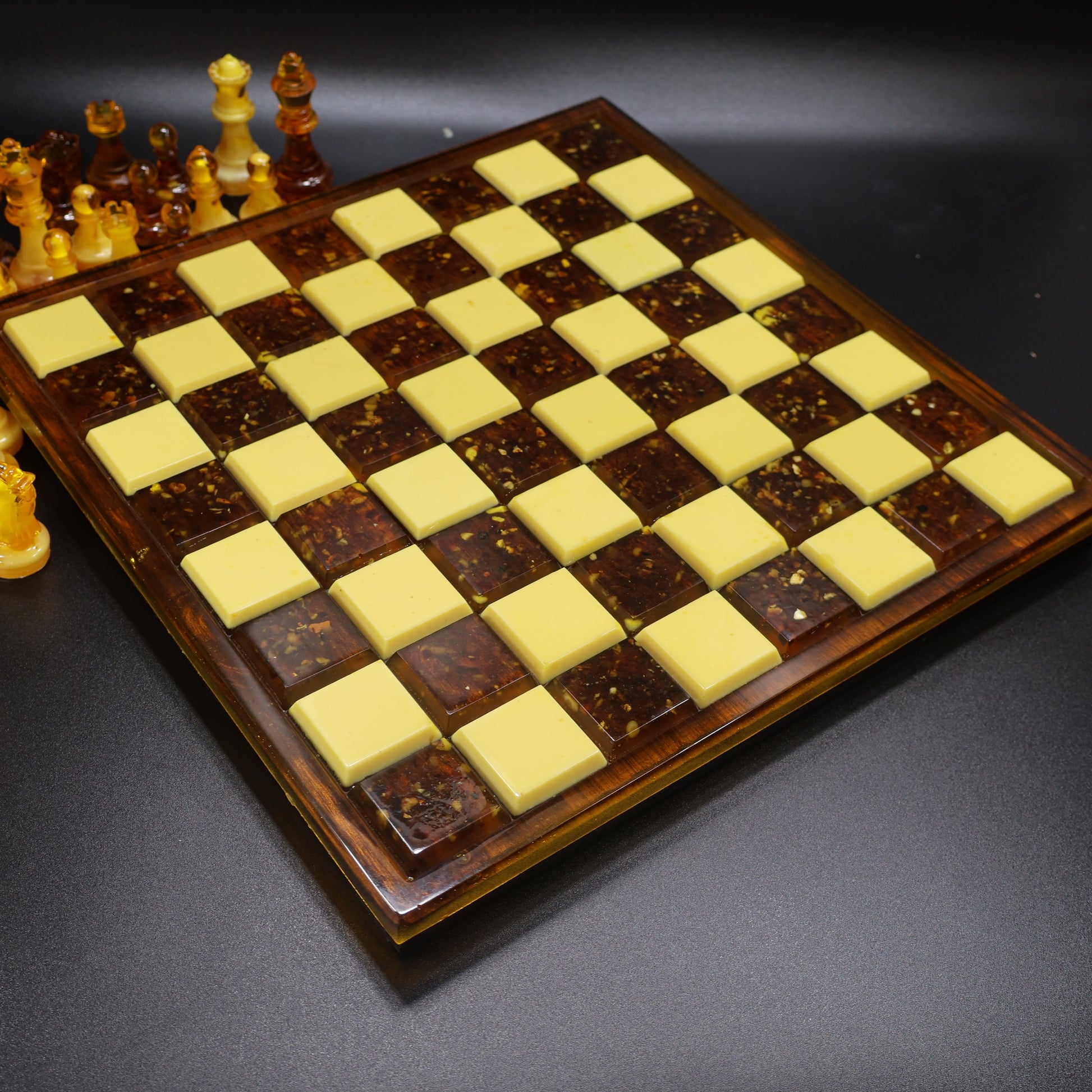 Deep amber chess board with warm wood frame and raised cream and cognac squares, handcrafted in USA KIZIMA