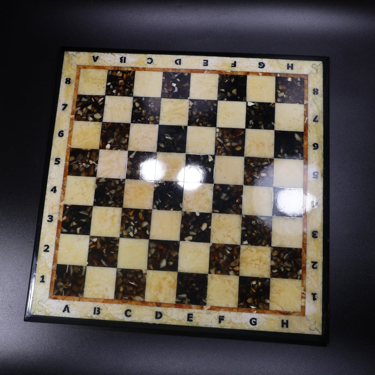 Baltic amber chess board top view showing honey and dark amber squares in wood inlay, KIZIMA Brooklyn New York
