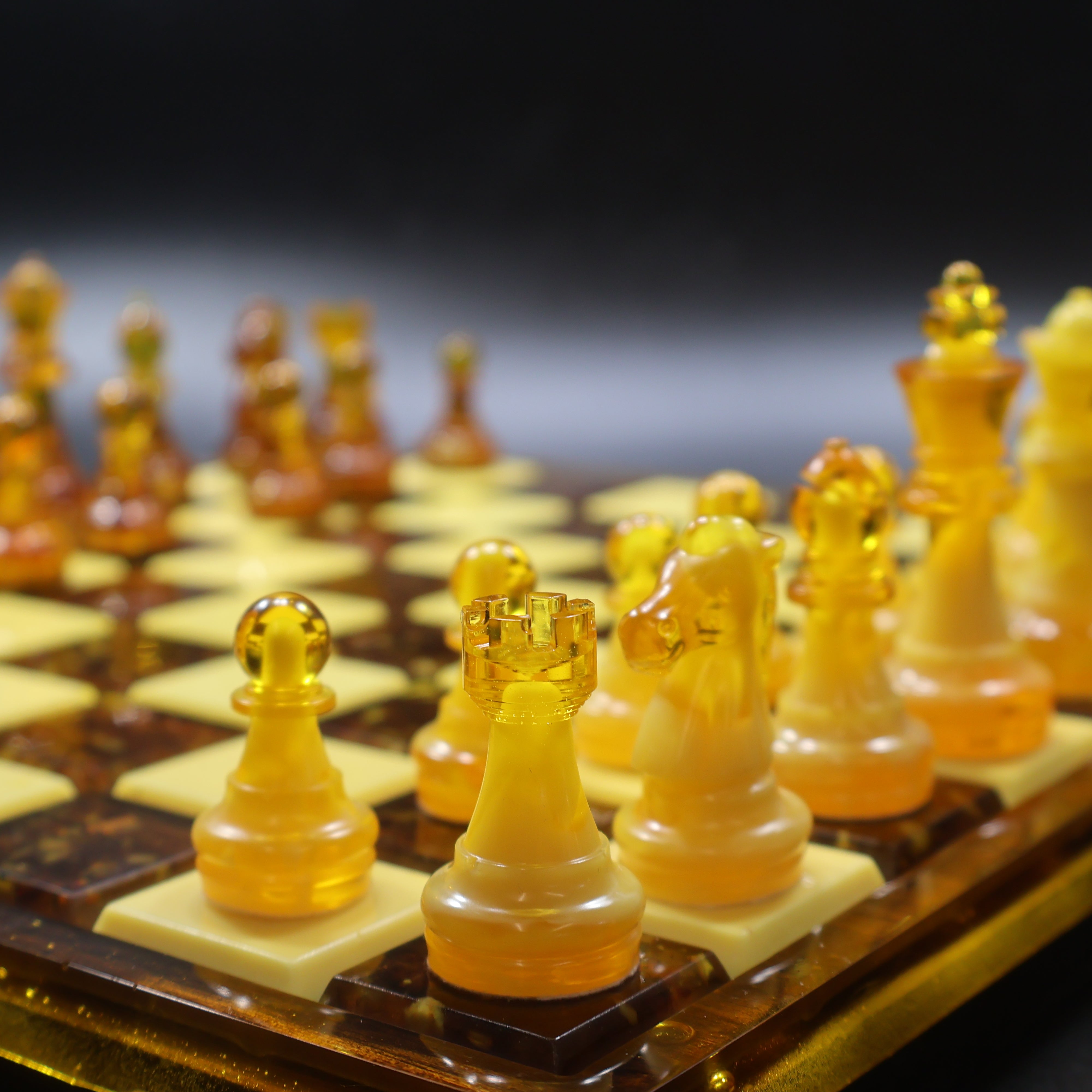 Genuine Baltic amber chess pieces arranged on rattan-inlaid wooden chess board, luxury handcrafted amber chess set KIZIMA USA