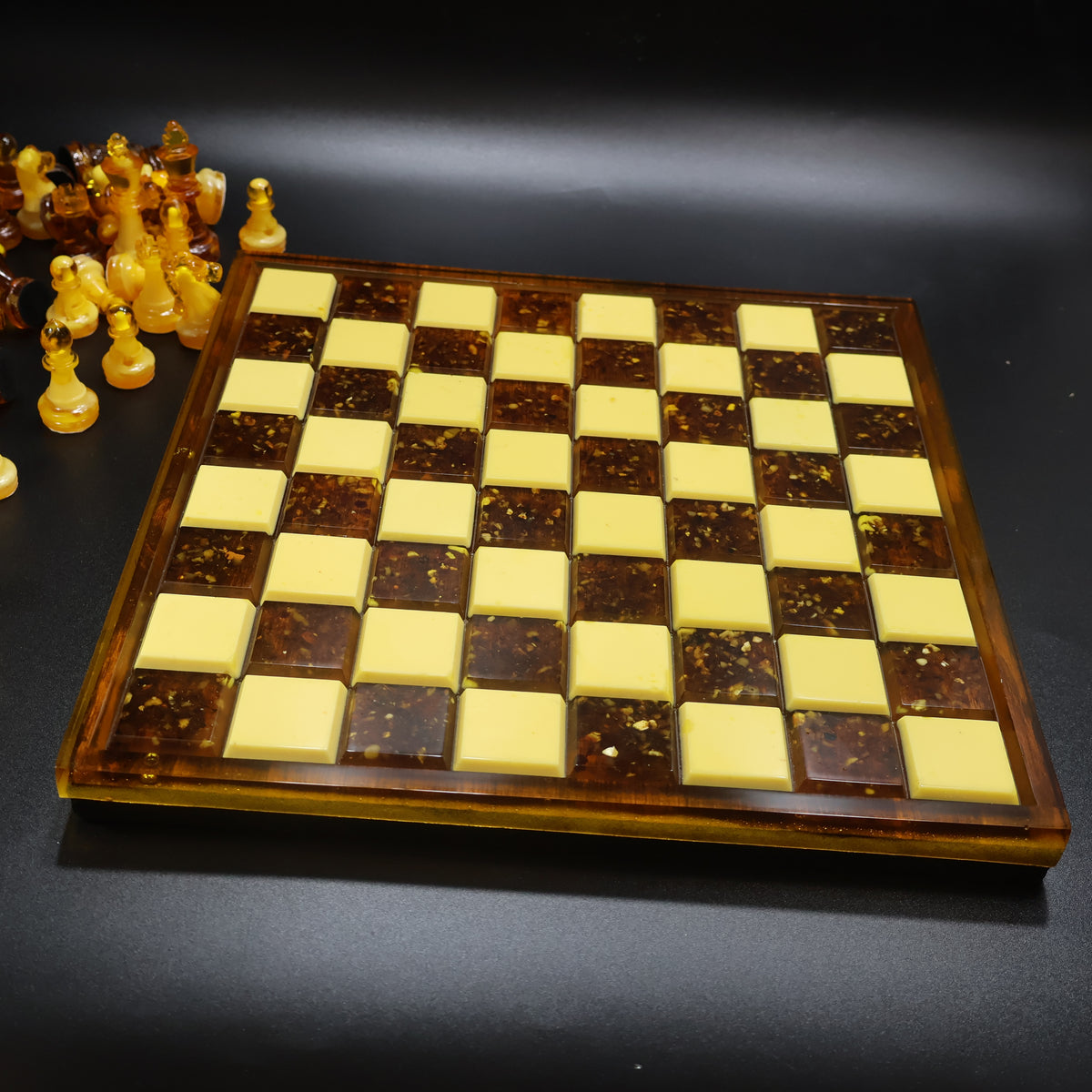 Amber chess board angled view showing thickness of wood frame and glossy amber inlay squares, made in USA KIZIMA