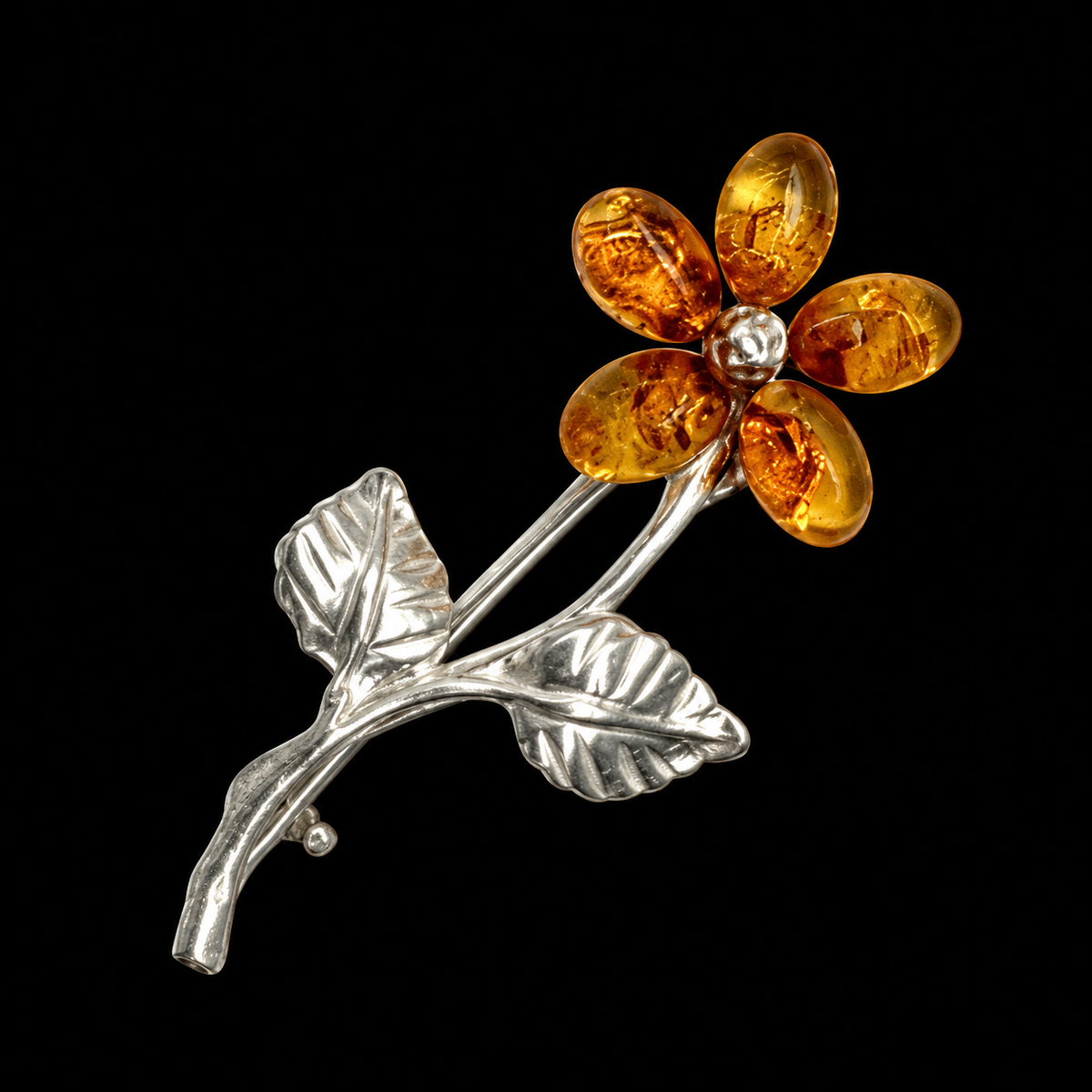 KIZIMA five-petal cognac amber flower brooch with silver-tone stem and leaves on matte black.