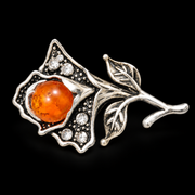 KIZIMA silver-tone flower brooch 20N0120q3.9 with orange amber and clear crystals on a black background.