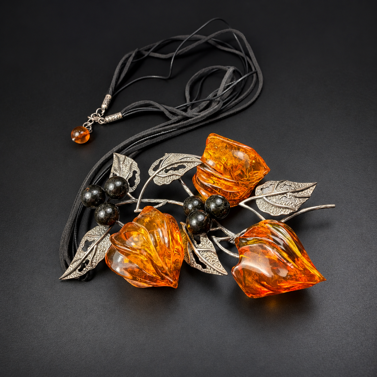 Diagonal full view of amber blossom necklace and multi-strand black cord, studio view 5
