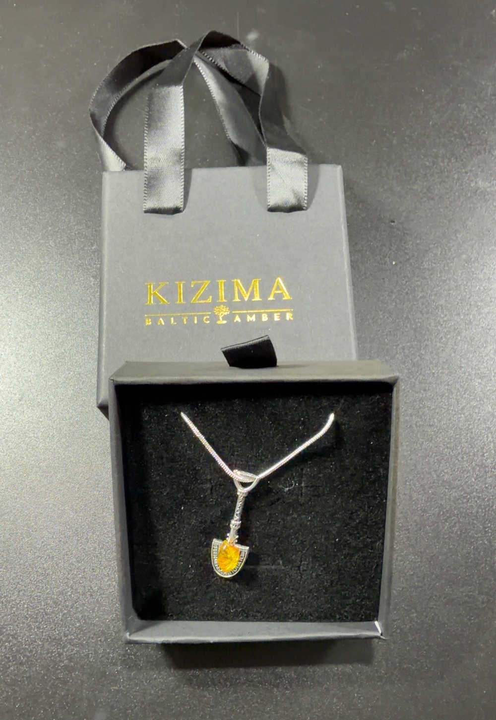 Original KIZIMA money shovel necklace in its gift box with branded gift bag
