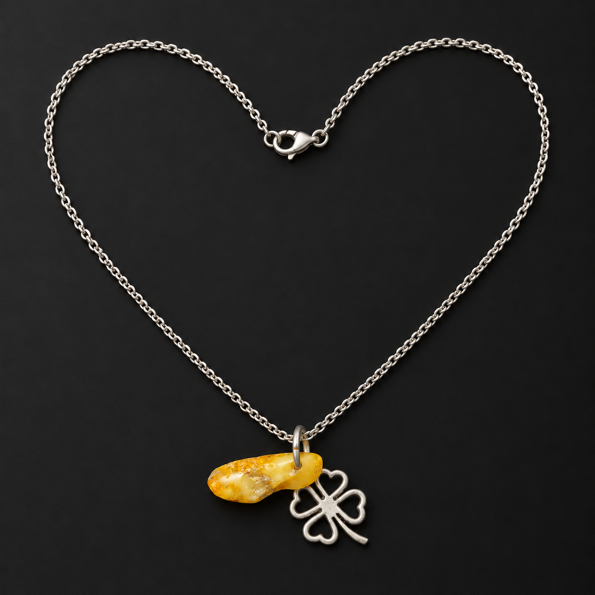 Made in USA Natural Baltic Amber four-leaf clover necklace by KIZIMA®, 45 cm chain arranged in a heart on black