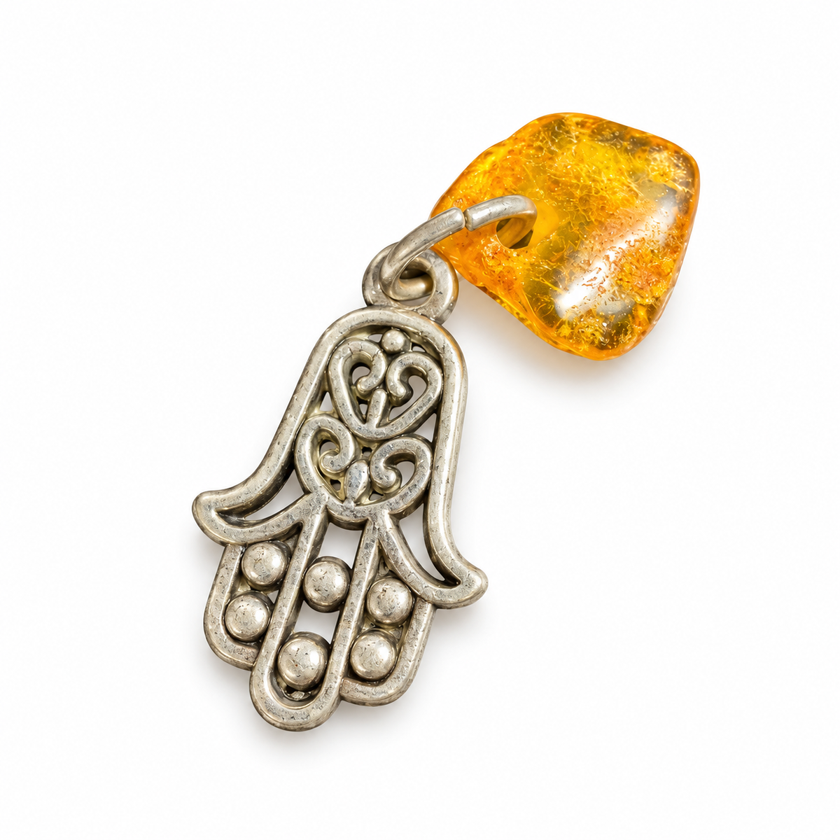 Made in USA Natural Baltic Amber Hamsa amulet by KIZIMA® with curled metal filigree and raised dots along the fingers on white