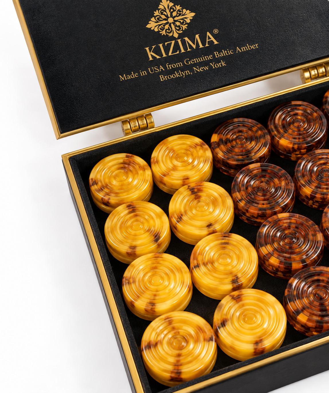 KIZIMA Baltic amber backgammon checkers in black gold-trim gift box, honey butterscotch and cognac pieces, close-up