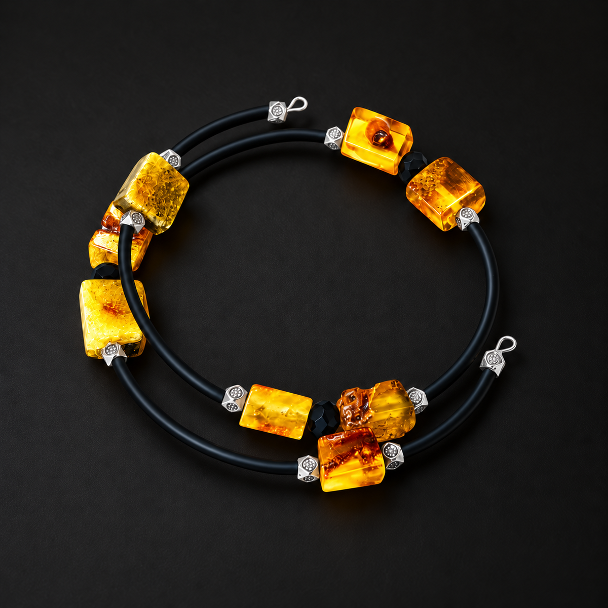 KIZIMA yellow amber spiral bracelet with black tubular cord and silver-tone spacers on black
