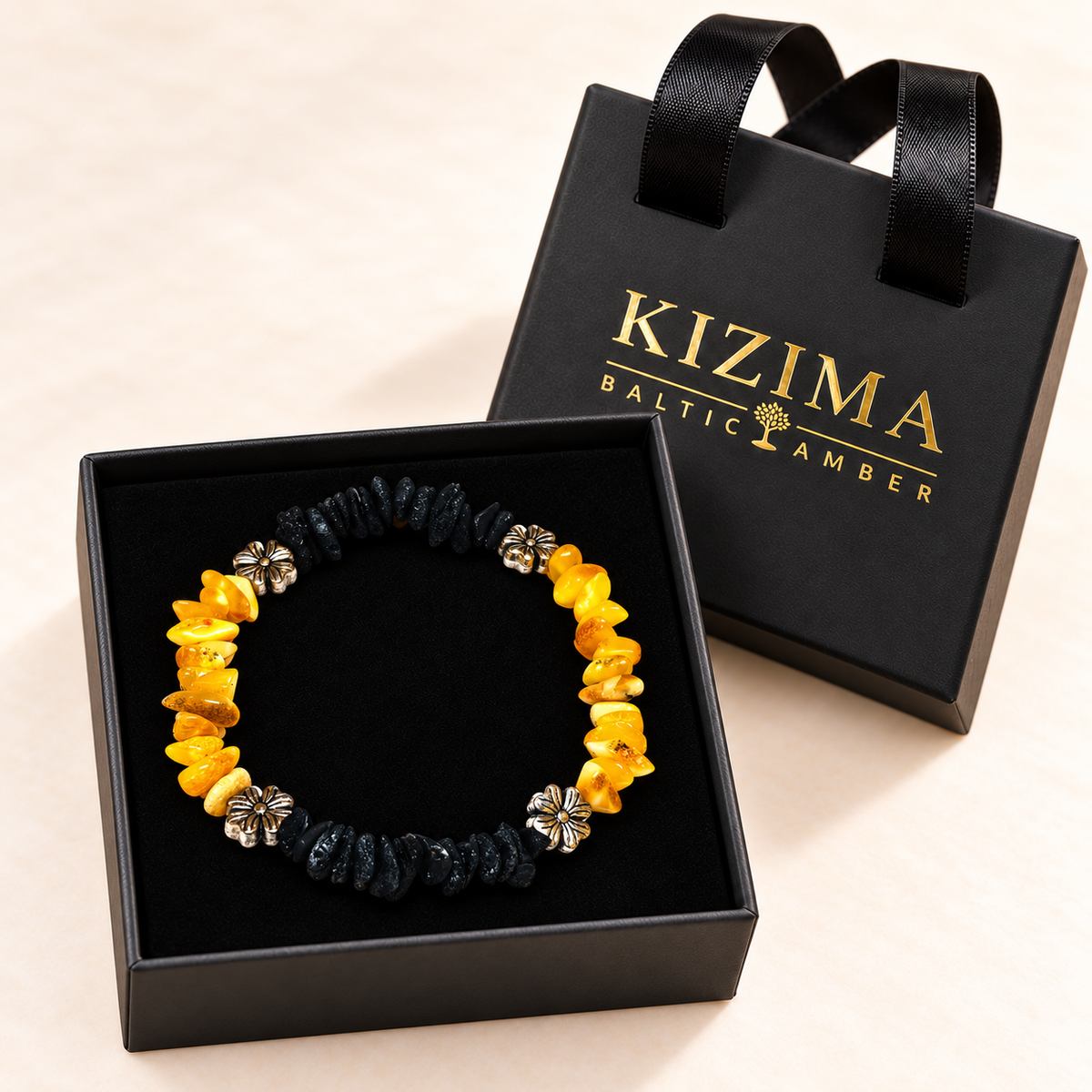 Yellow and black amber chip bracelet arranged on pristine black velvet inside a KIZIMA gift box.
