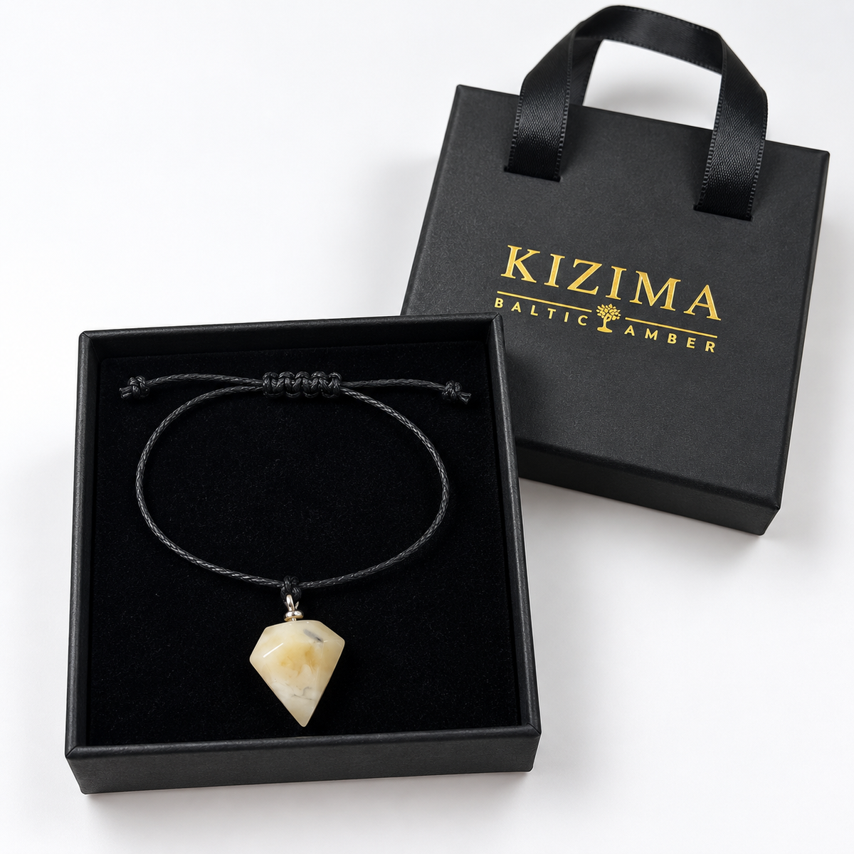 KIZIMA 3G0125q0.80 cream amber pointed pendant bracelet on black cord in a black KIZIMA gift box with gold logo
