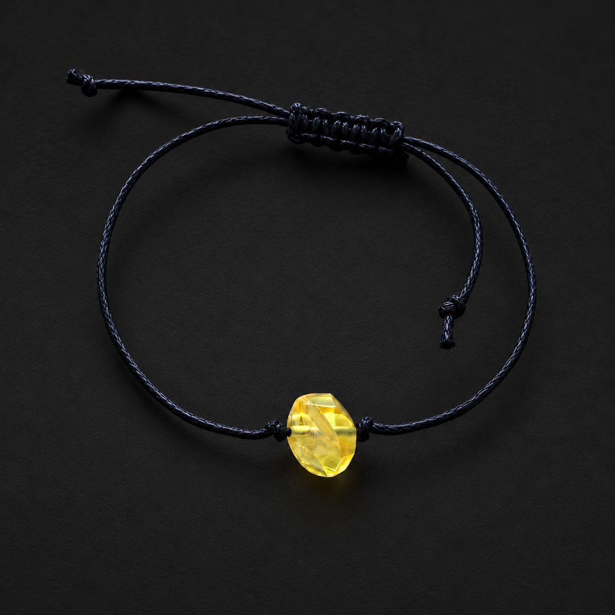 KIZIMA single pale yellow amber stone bracelet with black adjustable cord in a black studio setting
