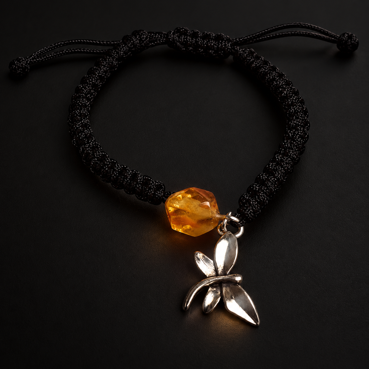 KIZIMA 3G0125q2.76-1 honey amber black macrame bracelet with silver-tone dragonfly charm on a black studio background