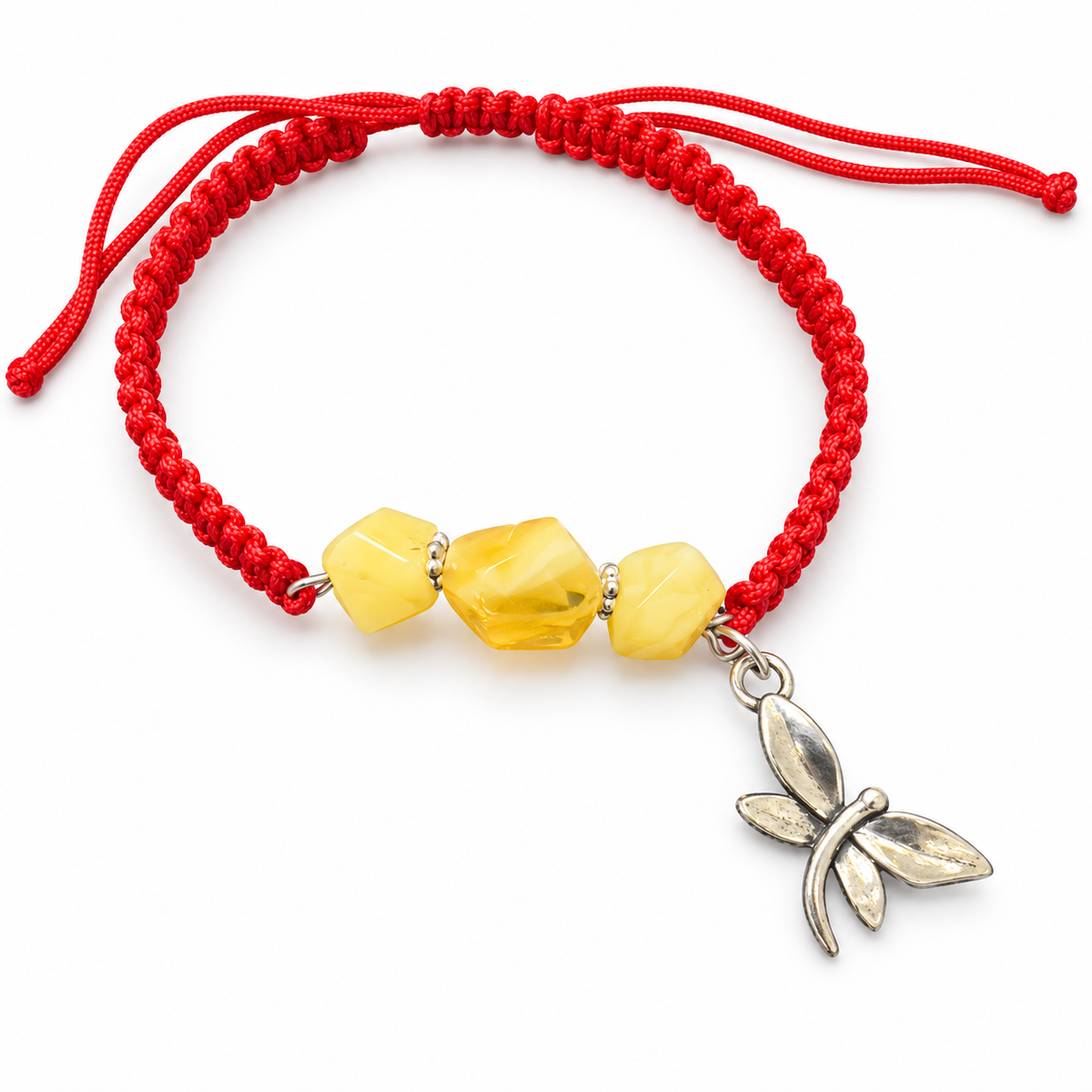KIZIMA three yellow amber stones and silver-tone dragonfly charm on red macrame bracelet against a pure white background