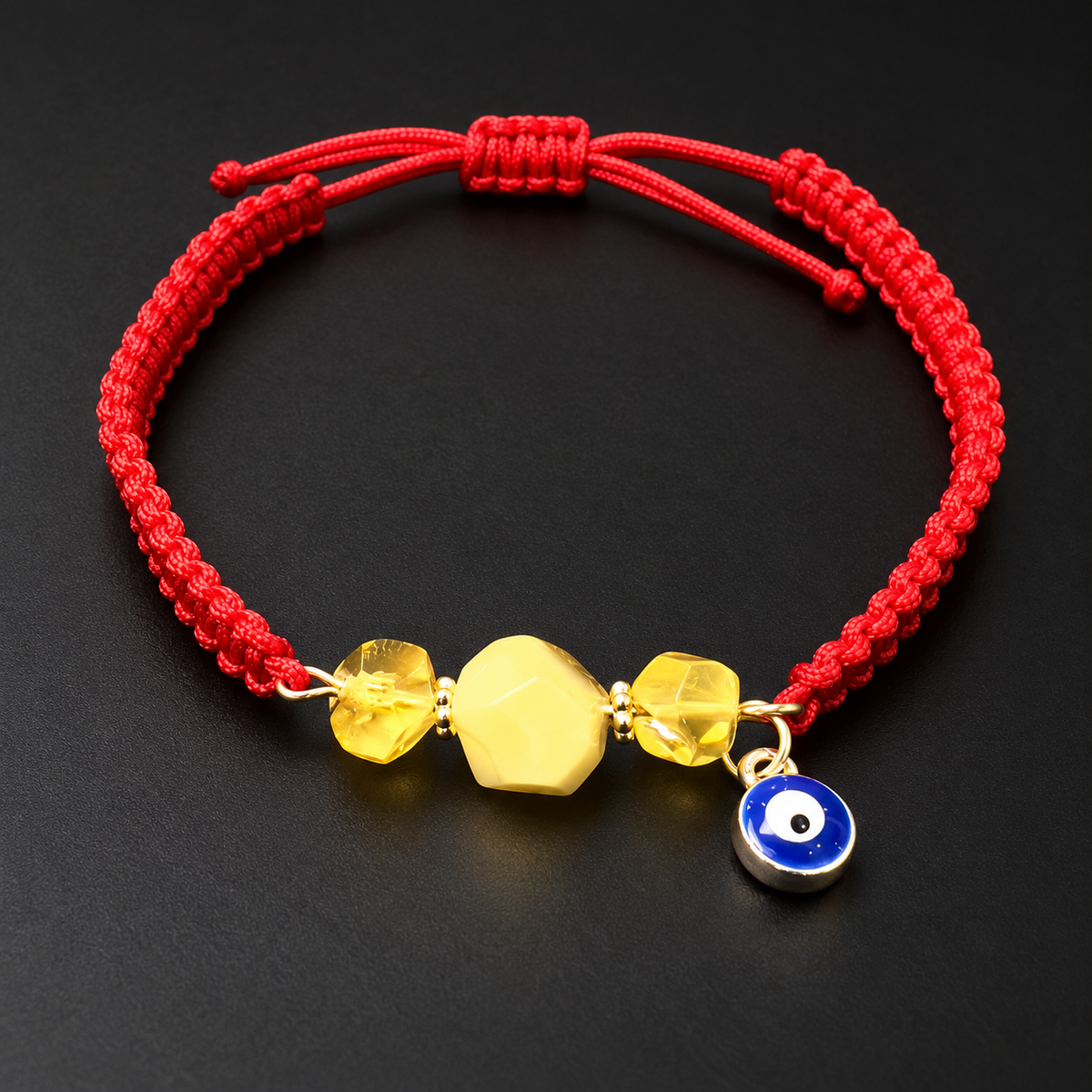 KIZIMA 3G0125q2.81-7 three-bead yellow and honey amber red macrame bracelet with blue evil-eye charm on a black studio background