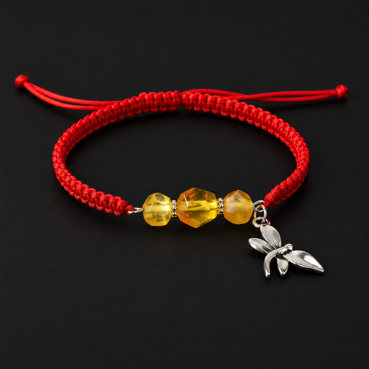 KIZIMA three golden amber bead bracelet with red macrame cord and a silver-tone dragonfly on black