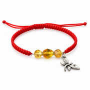 Red adjustable macrame bracelet with three transparent golden amber beads and a dragonfly charm on white