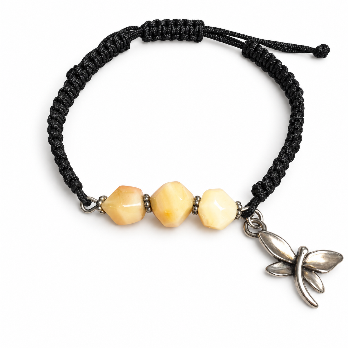 KIZIMA three cream amber stones and silver-tone dragonfly charm on black macrame bracelet against a pure white background