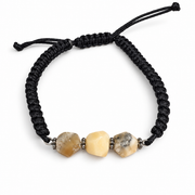 KIZIMA three-stone cream and gray-included amber bracelet on black macrame on a pure white background