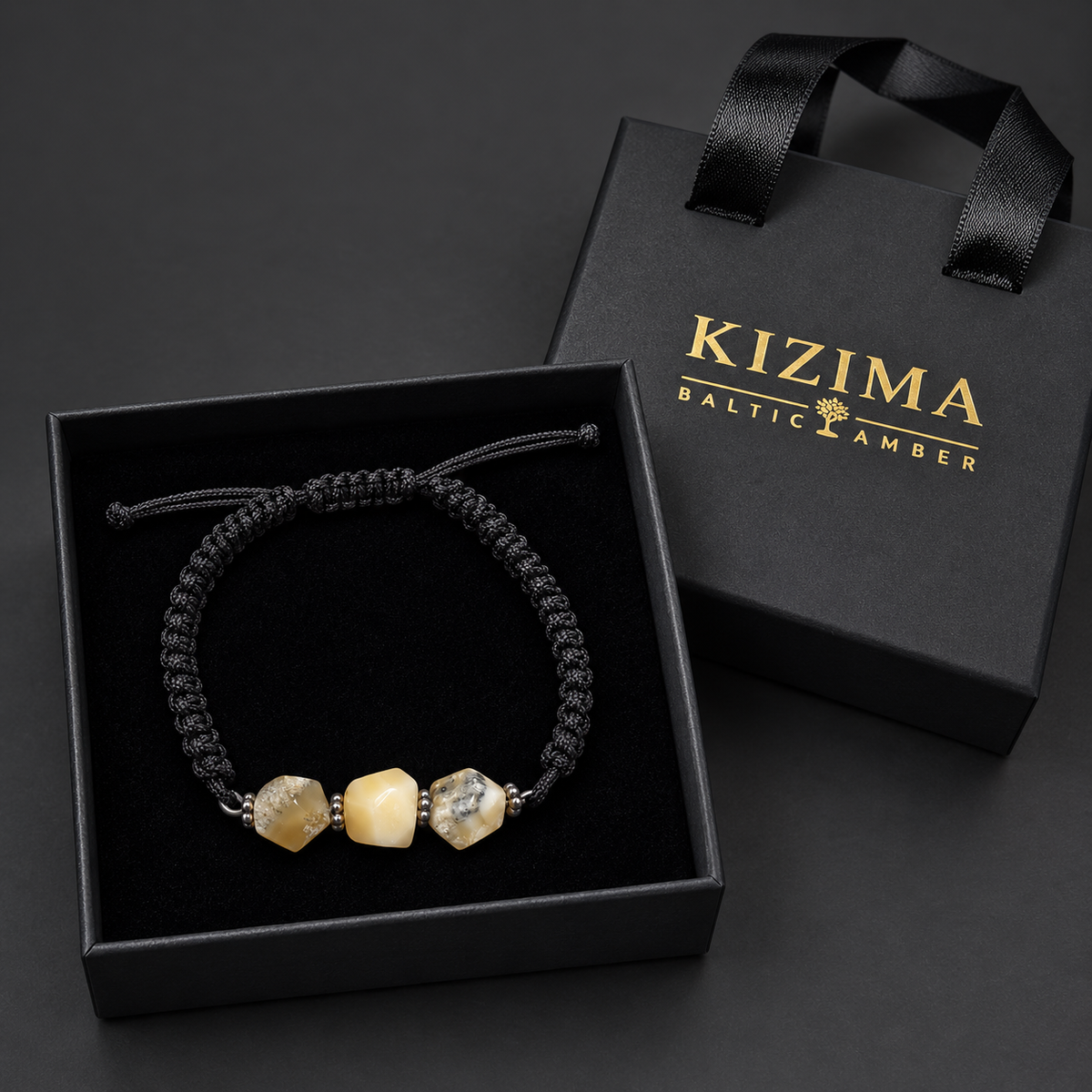 KIZIMA three-stone cream and gray-included amber bracelet on black macrame in a black KIZIMA gift box with clean black velvet