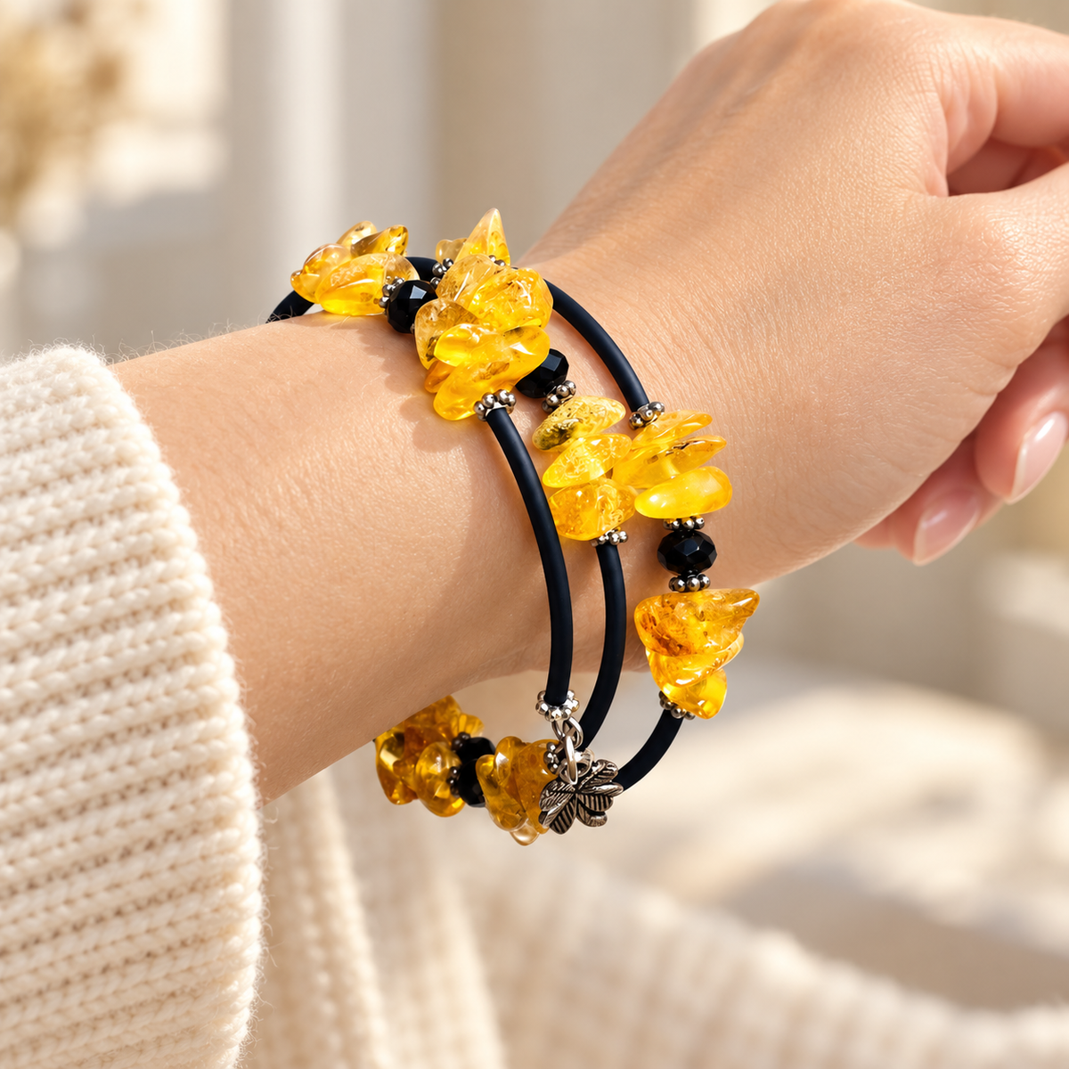 KIZIMA 3G250q16 three-coil spiral bracelet with yellow amber, dark navy sections and black faceted beads worn on a woman's wrist