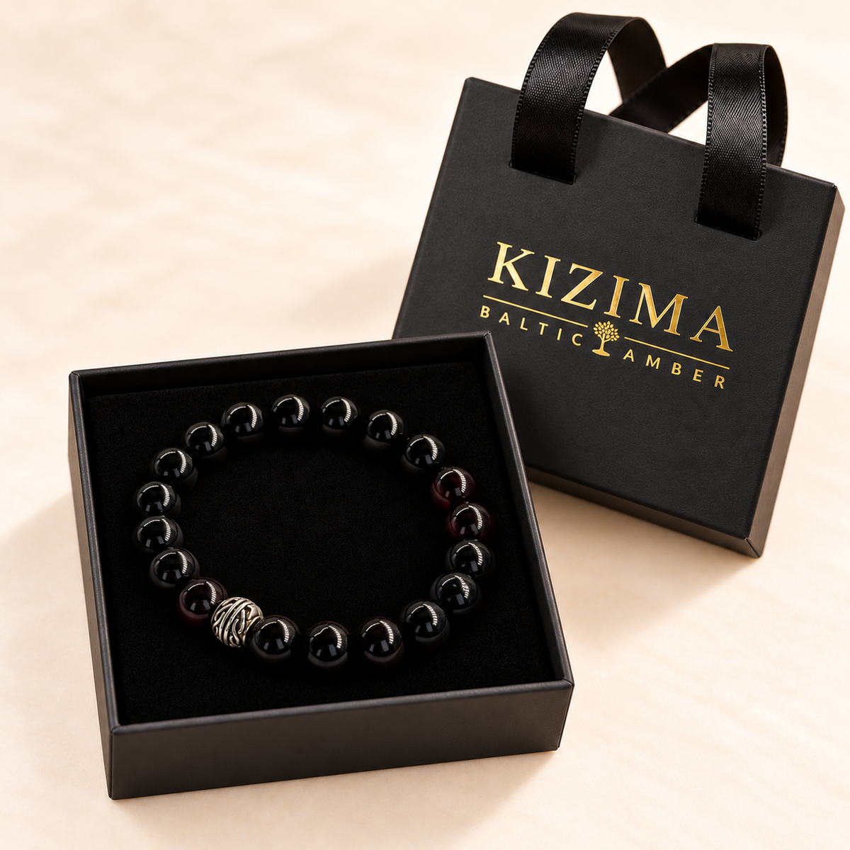 Black amber bead bracelet resting on clean black velvet inside the KIZIMA gift box.