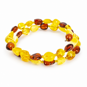 KIZIMA two-turn yellow and cognac amber pebble spiral bracelet against a pure white background