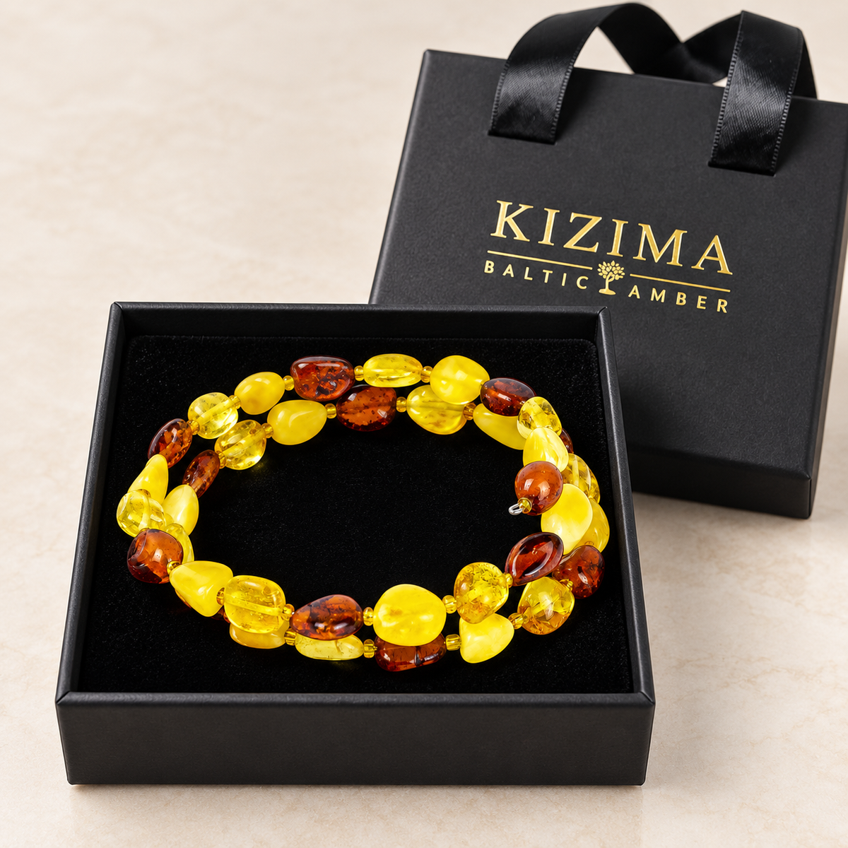 KIZIMA two-turn yellow and cognac amber pebble spiral bracelet inside a black KIZIMA gift box