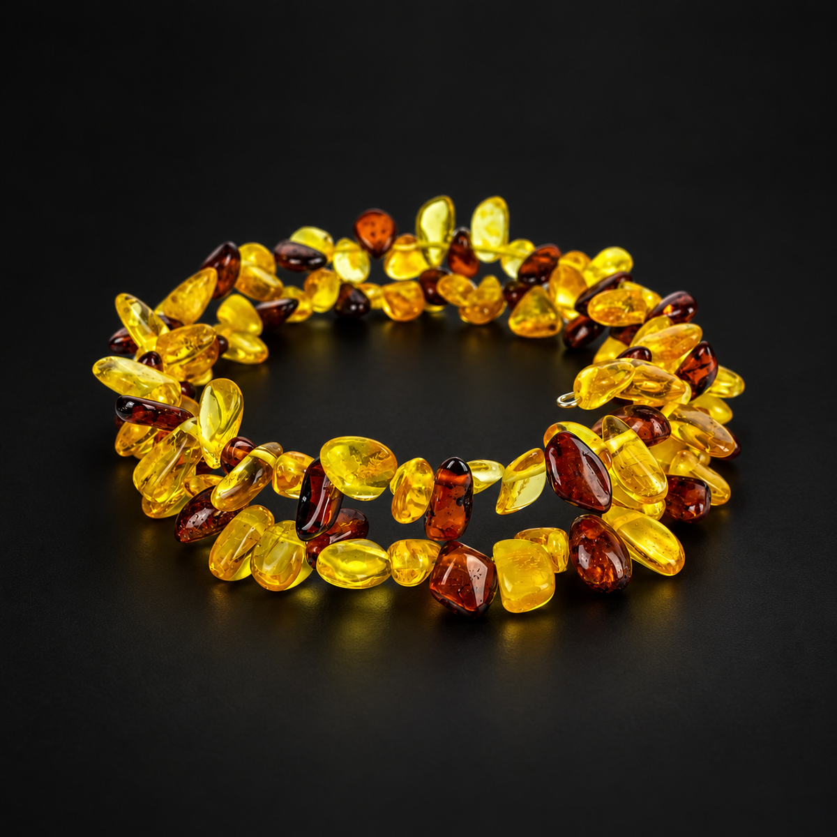 Two-turn yellow and cognac amber chip spiral bracelet by KIZIMA on a matte black studio background.