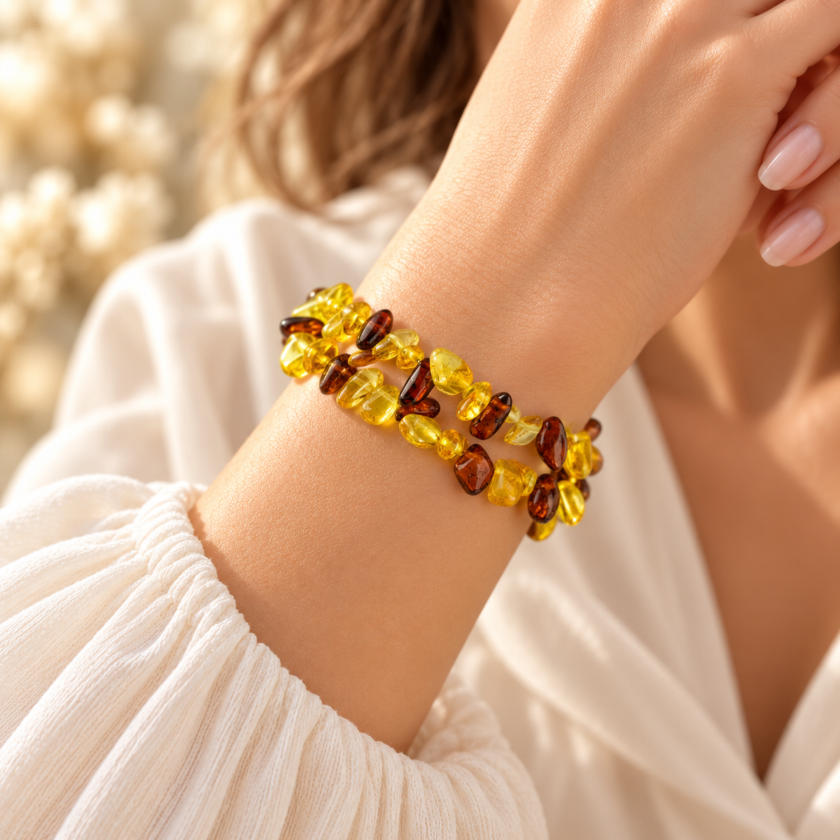 KIZIMA amber spiral bracelet wrapping a woman's wrist with polished lemon-yellow and cognac chips.