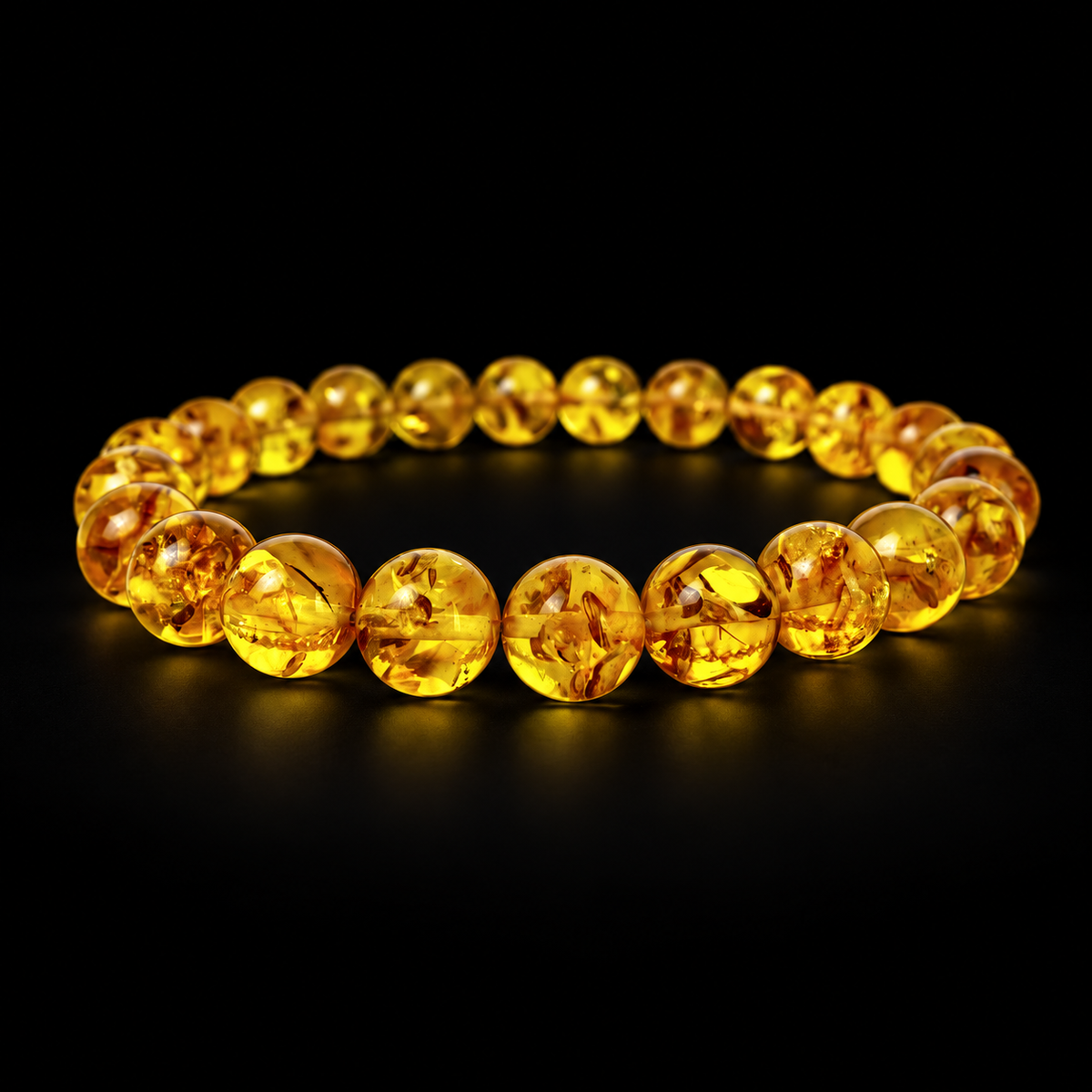 KIZIMA transparent honey-yellow round amber bead bracelet photographed against premium black.