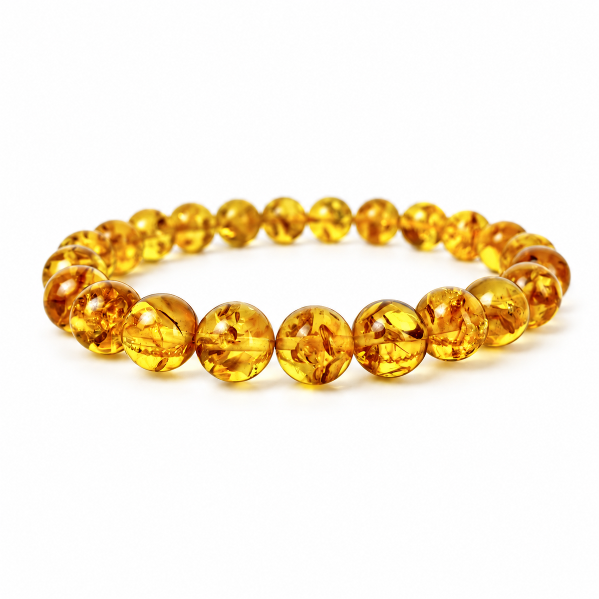 Polished spherical honey-yellow amber beads with natural internal flakes on pure white.