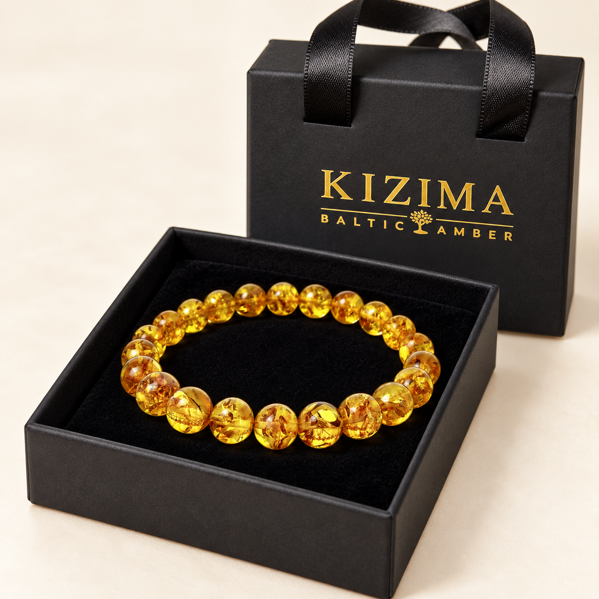 Round honey-yellow amber bracelet nestled on clean black velvet in its KIZIMA gift box.