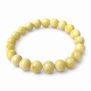 Twenty-one polished milky amber beads in a single-strand bracelet on pure white.